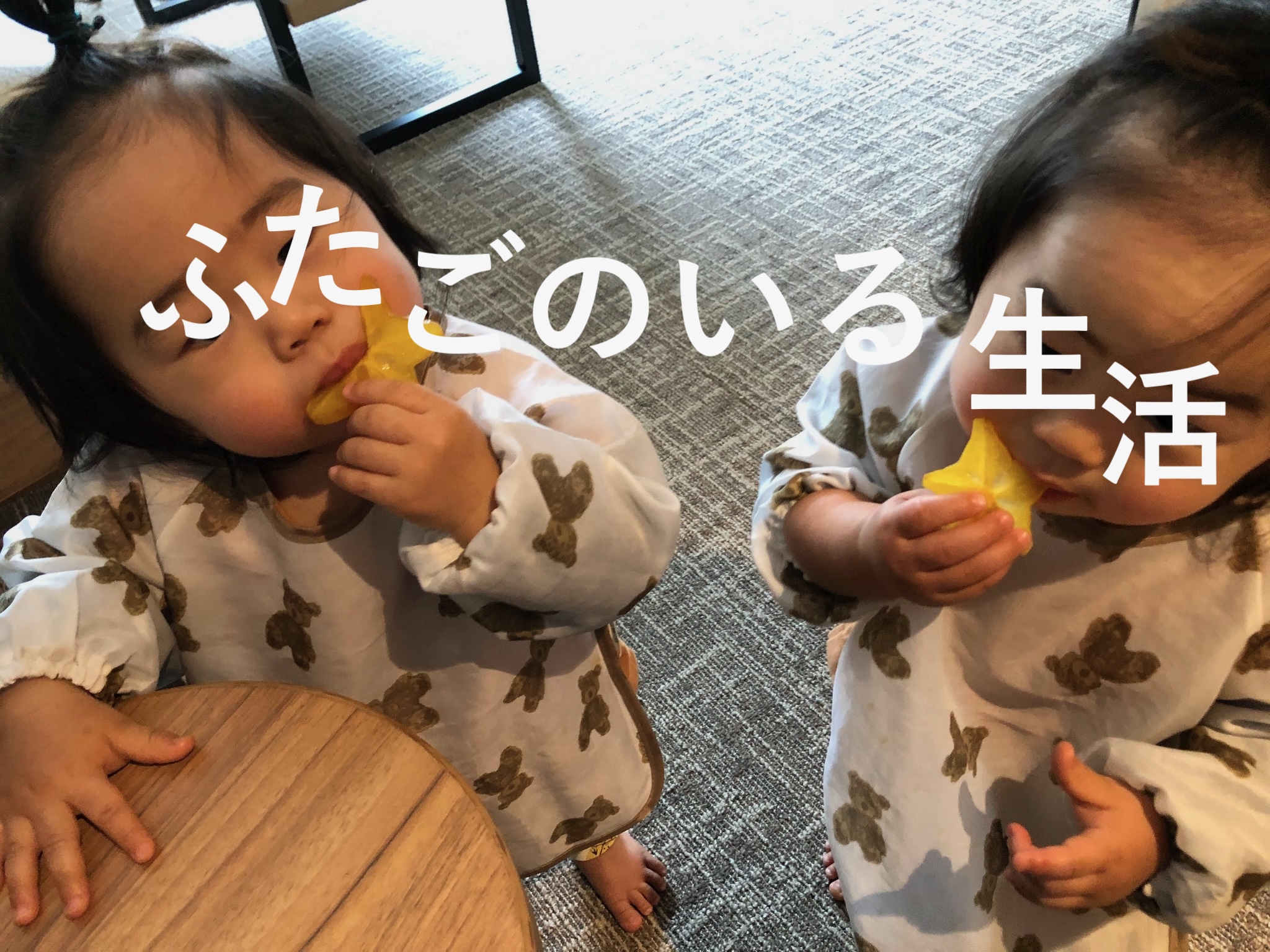 双子が手づかみでフルーツを食べている様子